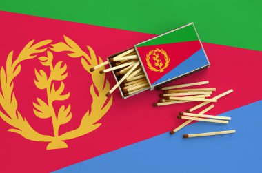 Eritre bayrak bir kibrit kutusu içinden birkaç sonbahar eşleşir ve büyük bir bayrak üzerinde yatıyor açık gösterilir.