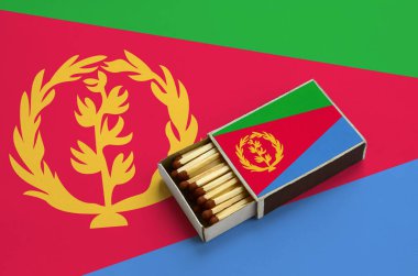 Eritre bayrak açık bir kibrit kutusu içinde gösterilen hangi dolu maçlar ve büyük bir bayrak üzerinde yatıyor.