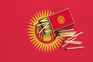 Kırgızistan bayrağı bir kibrit kutusu içinden birkaç sonbahar eşleşir ve büyük bir bayrak üzerinde yatıyor açık gösterilir.