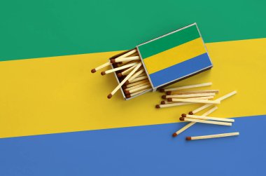 Gabon bayrak bir kibrit kutusu içinden birkaç sonbahar eşleşir ve büyük bir bayrak üzerinde yatıyor açık gösterilir.