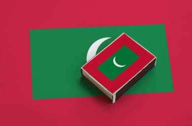 Maldivler bayrağı üzerinde büyük bir bayrak yatıyor bir kibrit kutusu üzerinde resimde.