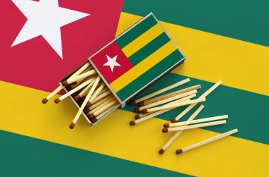 Togo bayrak bir kibrit kutusu içinden birkaç sonbahar eşleşir ve büyük bir bayrak üzerinde yatıyor açık gösterilir.