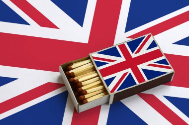 Büyük Britanya bayrağı açık bir kibrit kutusu içinde gösterilen hangi dolu maçlar ve büyük bir bayrak üzerinde yatıyor.