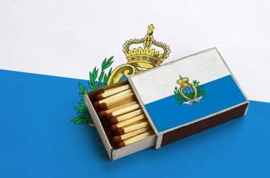 San Marino bayrağı açık bir kibrit kutusu içinde gösterilen hangi dolu maçlar ve büyük bir bayrak üzerinde yatıyor.