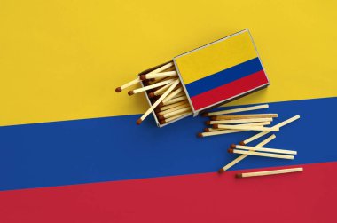 Kolombiya bayrak bir kibrit kutusu içinden birkaç sonbahar eşleşir ve büyük bir bayrak üzerinde yatıyor açık gösterilir.