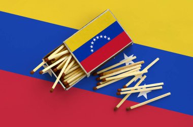 Venezuela bayrak bir kibrit kutusu içinden birkaç sonbahar eşleşir ve büyük bir bayrak üzerinde yatıyor açık gösterilir.