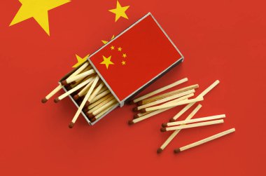 Çin bayrağı bir kibrit kutusu içinden birkaç sonbahar eşleşir ve büyük bir bayrak üzerinde yatıyor açık gösterilir.