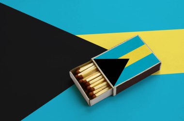 Bahamalar bayrağı açık bir kibrit kutusu içinde gösterilen hangi dolu maçlar ve büyük bir bayrak üzerinde yatıyor.