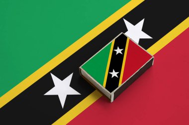 Saint Kitts ve Nevis bayrağı üzerinde büyük bir bayrak yatıyor bir kibrit kutusu üzerinde resimde.