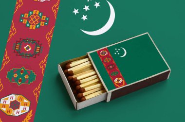 Türkmenistan bayrağı açık bir kibrit kutusu içinde gösterilen hangi dolu maçlar ve büyük bir bayrak üzerinde yatıyor.