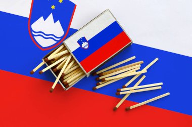 Slovenya bayrağı bir kibrit kutusu içinden birkaç sonbahar eşleşir ve büyük bir bayrak üzerinde yatıyor açık gösterilir.