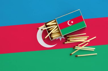 Azerbaycan bayrağı bir kibrit kutusu içinden birkaç sonbahar eşleşir ve büyük bir bayrak üzerinde yatıyor açık gösterilir.