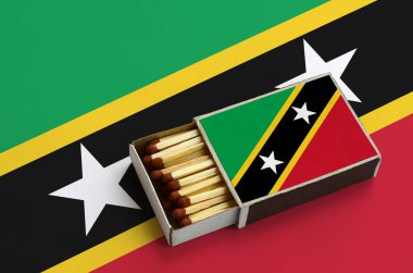 Saint Kitts ve Nevis bayrak açık bir kibrit kutusu içinde gösterilen hangi dolu maçlar ve büyük bir bayrak üzerinde yatıyor.