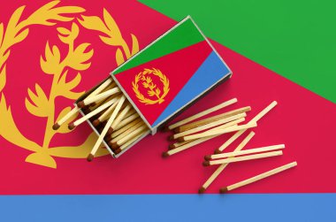 Eritre bayrak bir kibrit kutusu içinden birkaç sonbahar eşleşir ve büyük bir bayrak üzerinde yatıyor açık gösterilir.