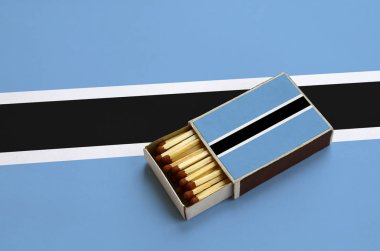 Botsvana bayrağı açık bir kibrit kutusu içinde gösterilen hangi dolu maçlar ve büyük bir bayrak üzerinde yatıyor.