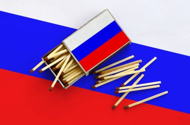 Rusya bayrağı bir kibrit kutusu içinden birkaç sonbahar eşleşir ve büyük bir bayrak üzerinde yatıyor açık gösterilir.