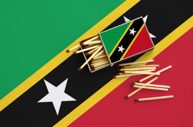Saint Kitts ve Nevis bayrak bir kibrit kutusu içinden birkaç sonbahar eşleşir ve büyük bir bayrak üzerinde yatıyor açık gösterilir.
