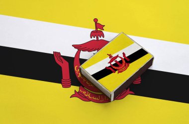 Brunei Darussalam bayrağı üzerinde büyük bir bayrak yatıyor bir kibrit kutusu üzerinde resimde.