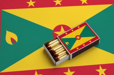 Grenada bayrağı açık bir kibrit kutusu içinde gösterilen hangi dolu maçlar ve büyük bir bayrak üzerinde yatıyor.