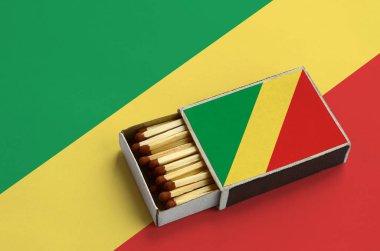 Kongo Cumhuriyeti bayrağı açık bir kibrit kutusu içinde gösterilen hangi dolu maçlar ve büyük bir bayrak üzerinde yatıyor.