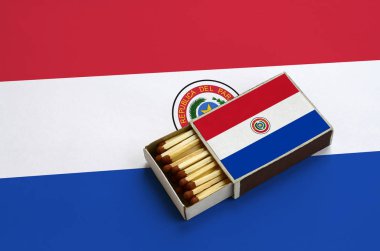 Paraguay bayrak açık bir kibrit kutusu içinde gösterilen hangi dolu maçlar ve büyük bir bayrak üzerinde yatıyor.