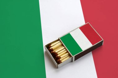 İtalya bayrağı açık bir kibrit kutusu içinde gösterilen hangi dolu maçlar ve büyük bir bayrak üzerinde yatıyor.