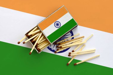 Hindistan bayrağı bir kibrit kutusu içinden birkaç sonbahar eşleşir ve büyük bir bayrak üzerinde yatıyor açık gösterilir.