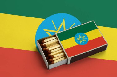 Etiyopya bayrağı açık bir kibrit kutusu içinde gösterilen hangi dolu maçlar ve büyük bir bayrak üzerinde yatıyor.