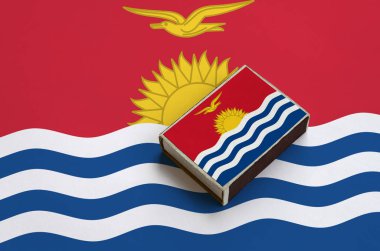 Kiribati bayrağı üzerinde büyük bir bayrak yatıyor bir kibrit kutusu üzerinde resimde.