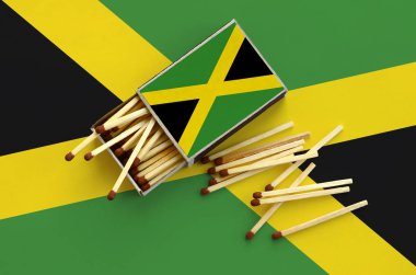 Jamaika bayrağını bir kibrit kutusu içinden birkaç sonbahar eşleşir ve büyük bir bayrak üzerinde yatıyor açık gösterilir.