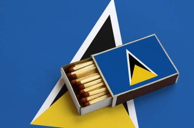 Saint Lucia bayrak açık bir kibrit kutusu içinde gösterilen hangi dolu maçlar ve büyük bir bayrak üzerinde yatıyor.