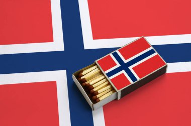 Norveç bayrağı açık bir kibrit kutusu içinde gösterilen hangi dolu maçlar ve büyük bir bayrak üzerinde yatıyor.