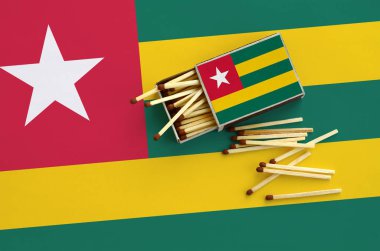 Togo bayrak bir kibrit kutusu içinden birkaç sonbahar eşleşir ve büyük bir bayrak üzerinde yatıyor açık gösterilir.