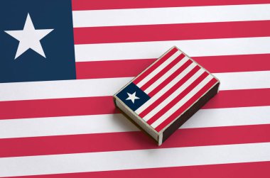 Liberya bayrağı üzerinde büyük bir bayrak yatıyor bir kibrit kutusu üzerinde resimde.