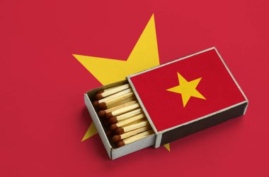 Vietnam bayrağı açık bir kibrit kutusu içinde gösterilen hangi dolu maçlar ve büyük bir bayrak üzerinde yatıyor.