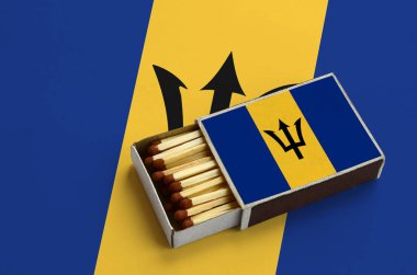 Barbados bayrağı açık bir kibrit kutusu içinde gösterilen hangi dolu maçlar ve büyük bir bayrak üzerinde yatıyor.