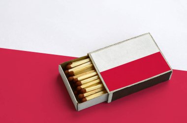 Polonya bayrağı açık bir kibrit kutusu içinde gösterilen hangi dolu maçlar ve büyük bir bayrak üzerinde yatıyor.