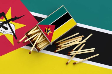 Mozambik bayrak bir kibrit kutusu içinden birkaç sonbahar eşleşir ve büyük bir bayrak üzerinde yatıyor açık gösterilir.
