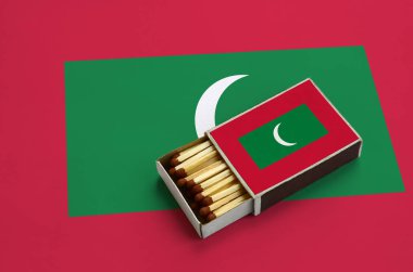 Maldivler bayrağı açık bir kibrit kutusu içinde gösterilen hangi dolu maçlar ve büyük bir bayrak üzerinde yatıyor.