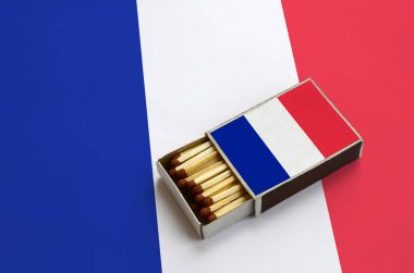 Fransa bayrağı açık bir kibrit kutusu içinde gösterilen hangi dolu maçlar ve büyük bir bayrak üzerinde yatıyor.