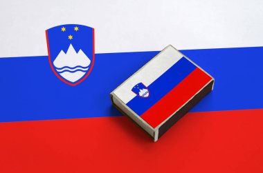 Slovenya bayrağı üzerinde büyük bir bayrak yatıyor bir kibrit kutusu üzerinde resimde.