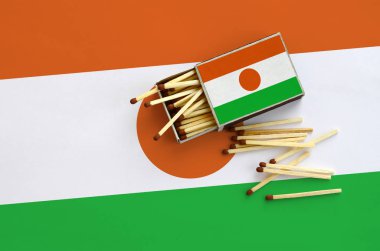 Nijer bayrak bir kibrit kutusu içinden birkaç sonbahar eşleşir ve büyük bir bayrak üzerinde yatıyor açık gösterilir.