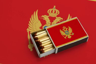 Karadağ bayrağı açık bir kibrit kutusu içinde gösterilen hangi dolu maçlar ve büyük bir bayrak üzerinde yatıyor.