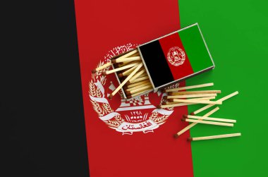Afganistan bayrağı bir kibrit kutusu içinden birkaç sonbahar eşleşir ve büyük bir bayrak üzerinde yatıyor açık gösterilir.