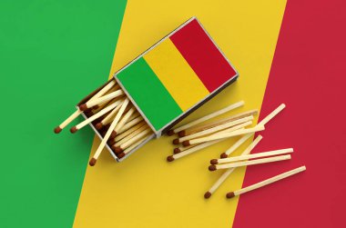 Mali bayrağı bir kibrit kutusu içinden birkaç sonbahar eşleşir ve büyük bir bayrak üzerinde yatıyor açık gösterilir.