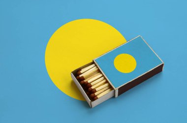 Palau bayrak açık bir kibrit kutusu içinde gösterilen hangi dolu maçlar ve büyük bir bayrak üzerinde yatıyor.