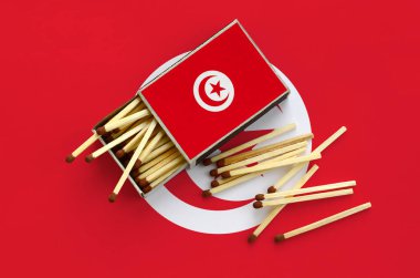 Tunus bayrağı bir kibrit kutusu içinden birkaç sonbahar eşleşir ve büyük bir bayrak üzerinde yatıyor açık gösterilir.
