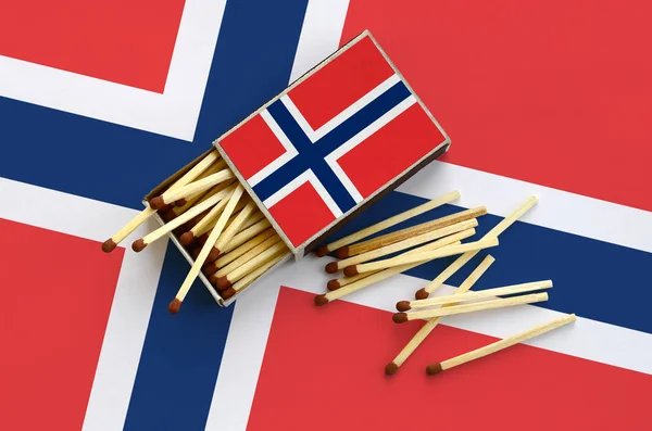 Norveç bayrağı bir kibrit kutusu içinden birkaç sonbahar eşleşir ve büyük bir bayrak üzerinde yatıyor açık gösterilir.
