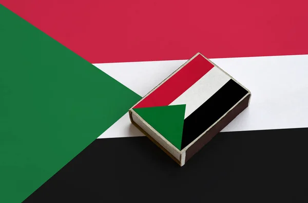 Флаг Судана Изображен Спичечной Коробке Которая Лежит Большом Флаге — стоковое фото