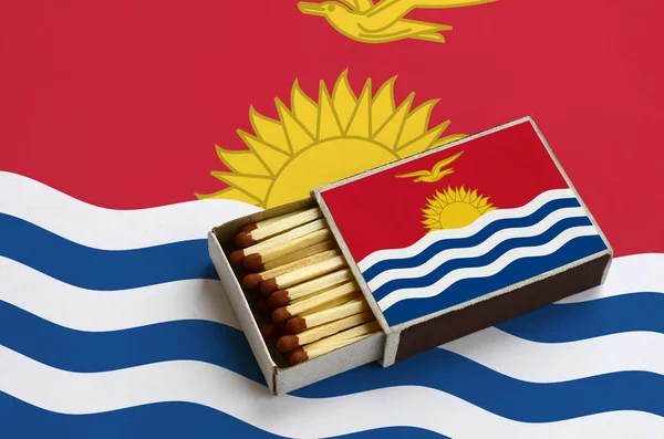 Kiribati bayrak açık bir kibrit kutusu içinde gösterilen hangi dolu maçlar ve büyük bir bayrak üzerinde yatıyor.
